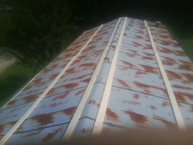Rusted metal roof panels with new wood purlins before replacement — Storm Damage Roof Repair in Swain by Roofing Brothers