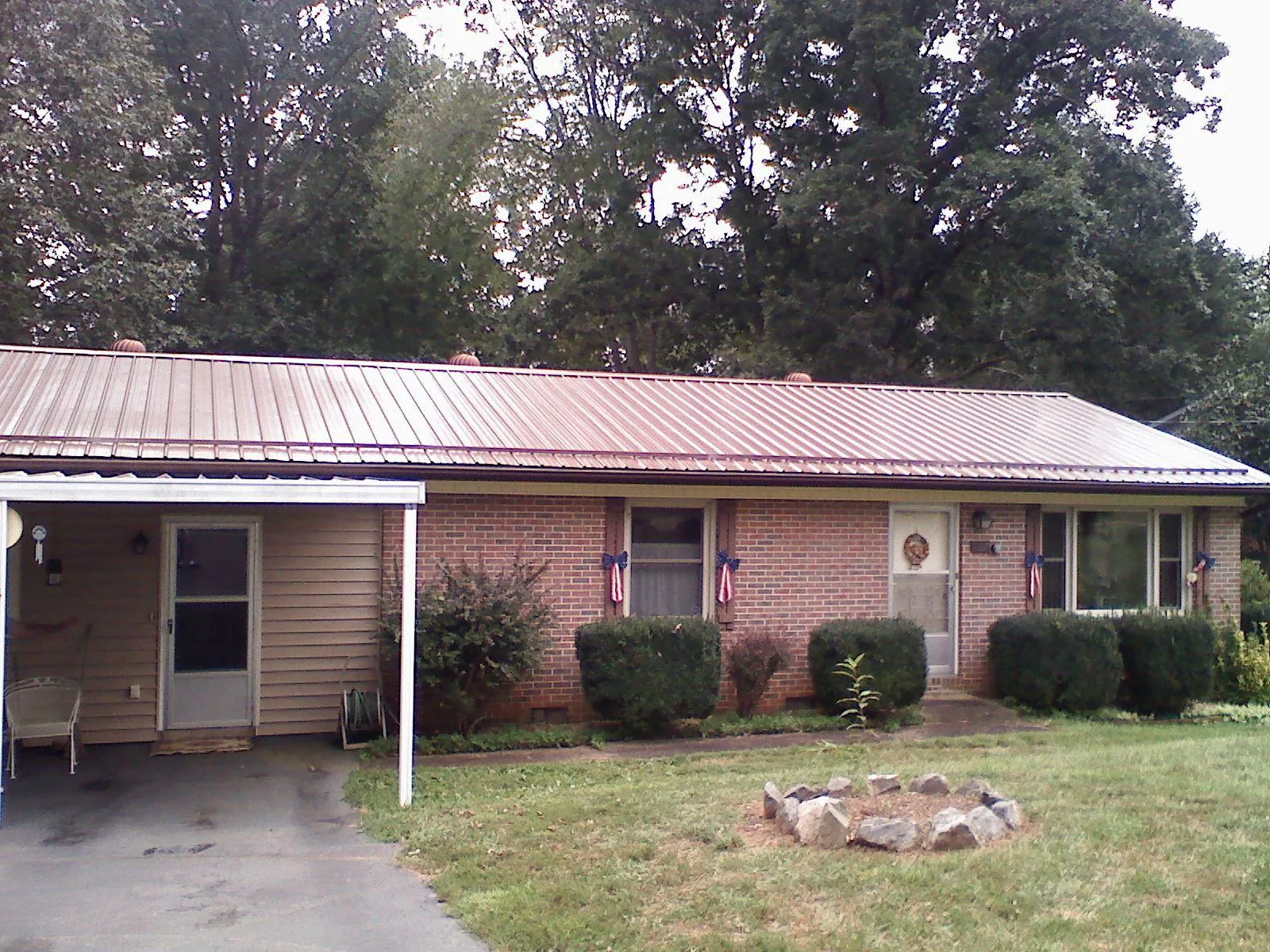 Bronze metal roof and carport on a brick ranch home — Roof Repair work by our crew in Swain